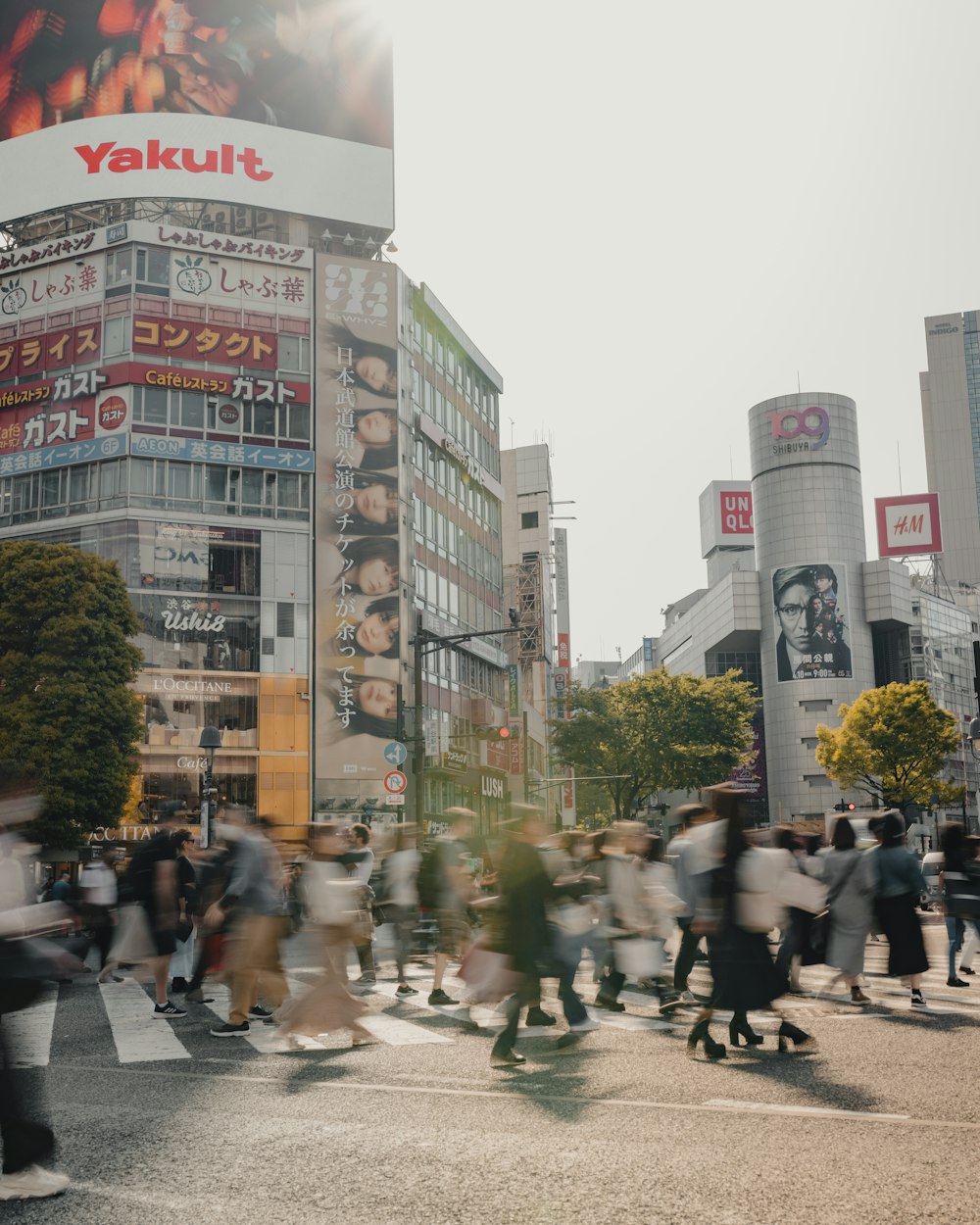 高層ビルの前の通りを横断する人々のグループ