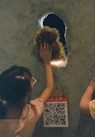 Close-up of a child reaching out to touch a 3D painted treasure chest that seems to pop out of the wall.