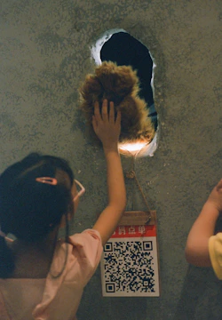 Children exploring a colorful sensory wall filled with textures and lights.