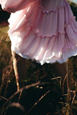 Soft focus shot of a flowing pastel dress moving gracefully in the breeze outdoors.