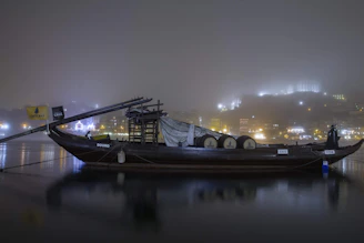 A traditional boat gliding along the calm waters of the Zambezi River at twilight.