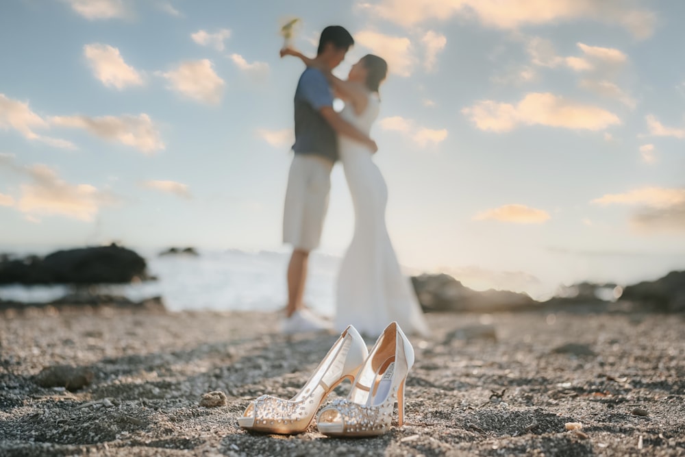 a bride and groom kissing on the beach