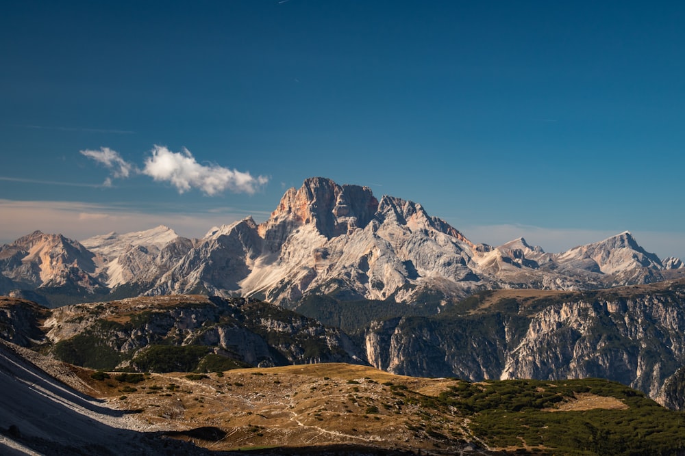 a view of a mountain range from the top of a hill