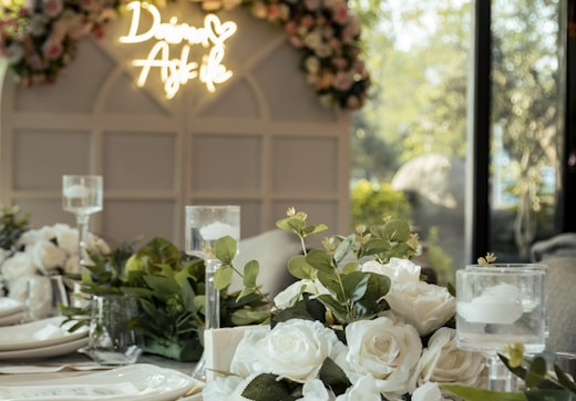 a table set for a formal dinner with flowers and candles