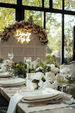 a table set for a formal dinner with flowers and candles