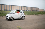 A smiling driver waving from the window of a 'come in soon' vehicle.