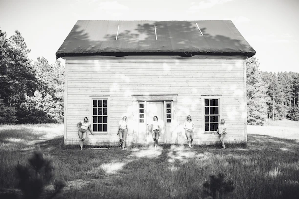 A historic black-and-white photo of the five founding members laying the foundation stone in 2013.