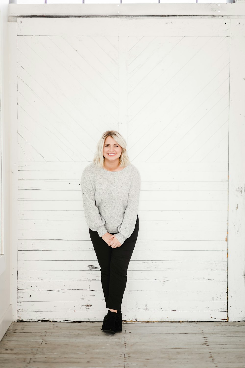 a woman standing in front of a white wall