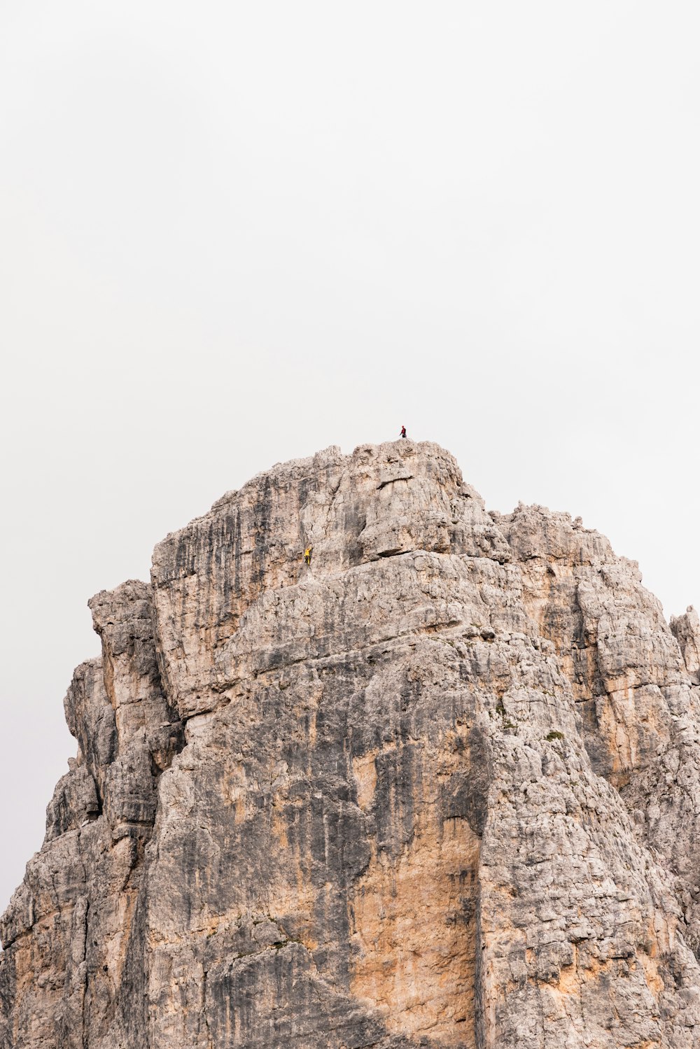 una persona de pie en la cima de una gran roca