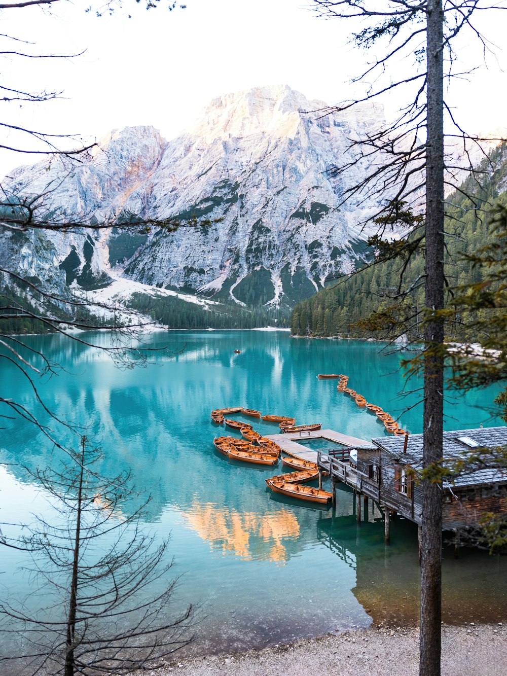 a lake surrounded by mountains with a dock in the middle