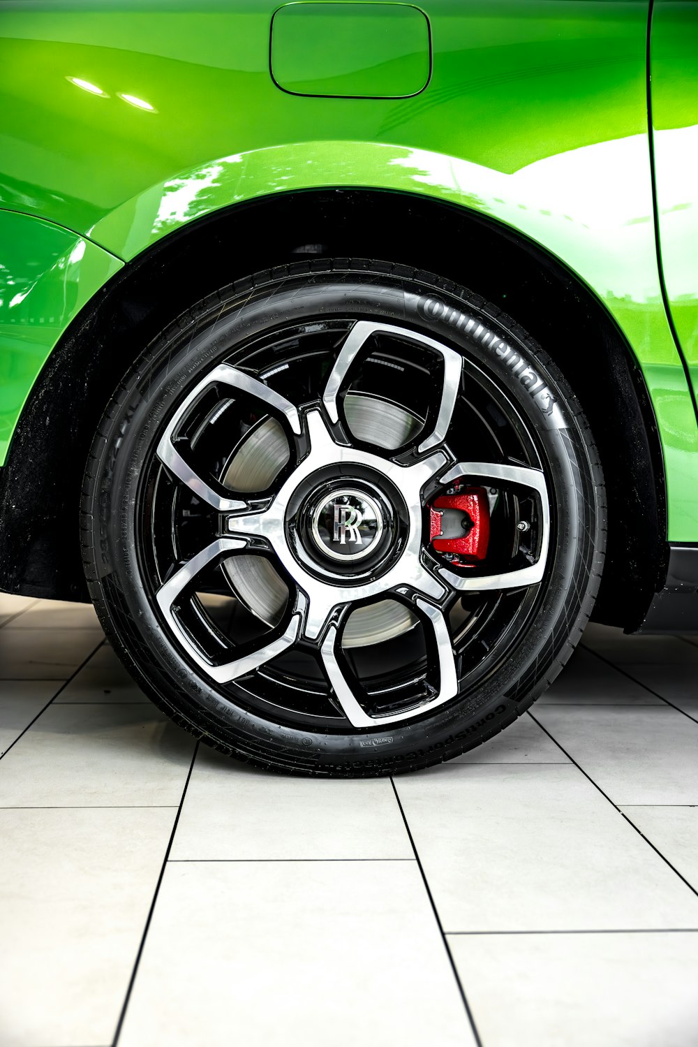 a close up of a green car on a tile floor