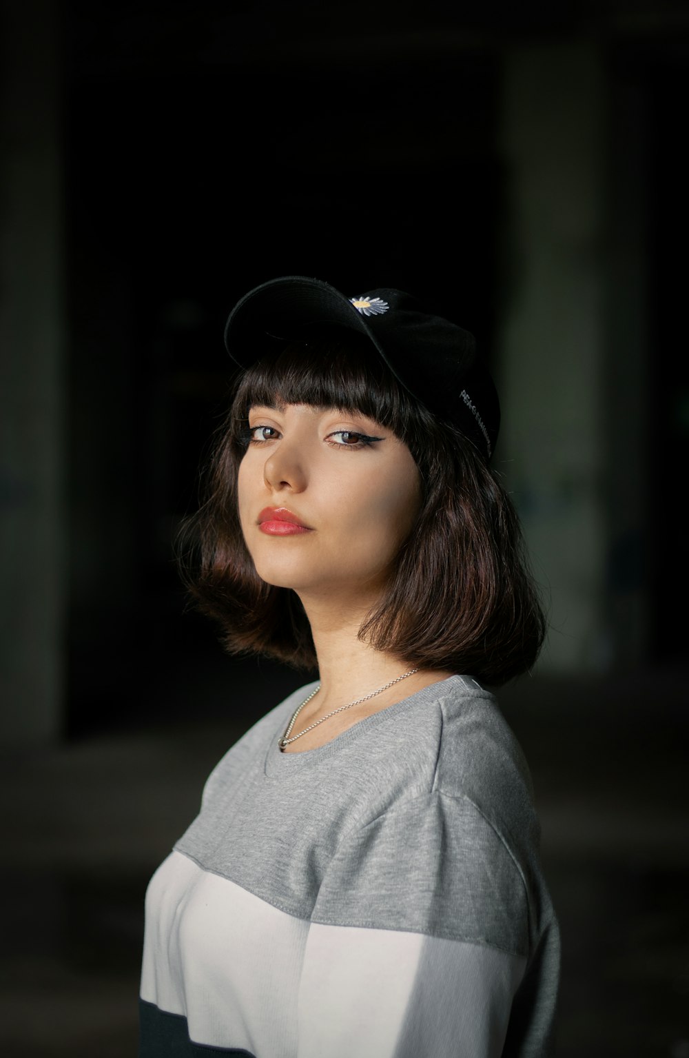 a woman wearing a black hat and grey shirt