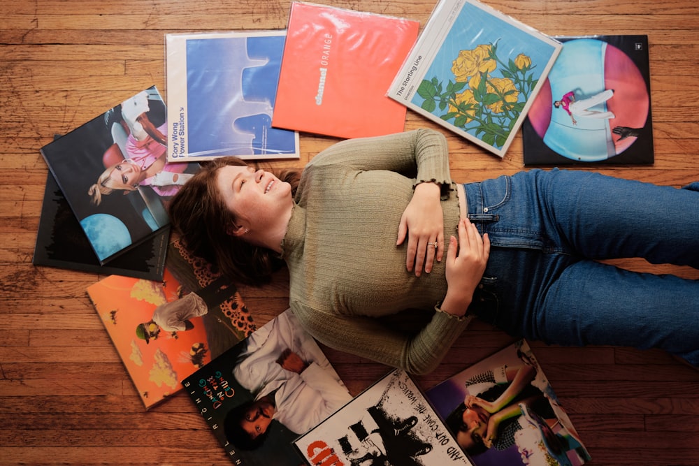 a woman laying on the floor surrounded by magazines