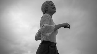 a black and white photo of a woman flying a kite