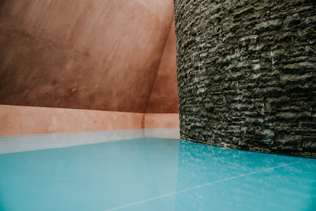 Cozy Scandinavian-style swimming pool with smooth exposed aggregate plaster and warm lighting.