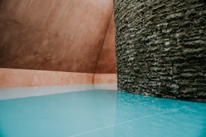 Modern private pool with seamless quartz sand-colored finish blending with natural surroundings