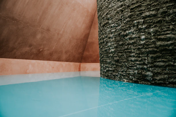 Minimalist modern pool under soft natural light with sleek gray and cobalt blue accents.