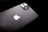 A black smartphone featuring a dual-lens camera and the iconic white apple logo. The device is slightly tilted against a dark background, highlighting its sleek and glossy finish.