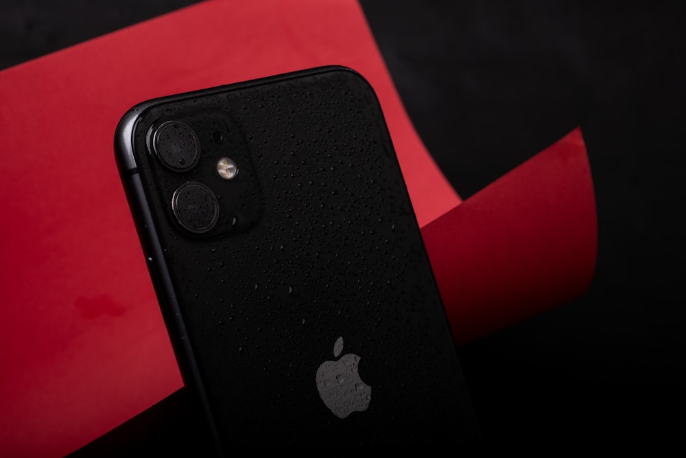 a close up of a black and red iphone
