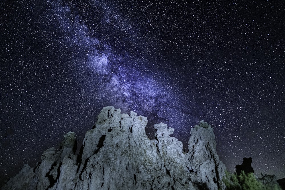 the night sky with stars above a mountain