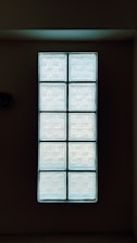 Stacked translucent glass blocks illuminated by natural light in a modern architectural setting.