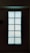 A rectangular arrangement of glass blocks with intricate patterns that allow light to pass through, creating a glowing effect against a dimly lit background.