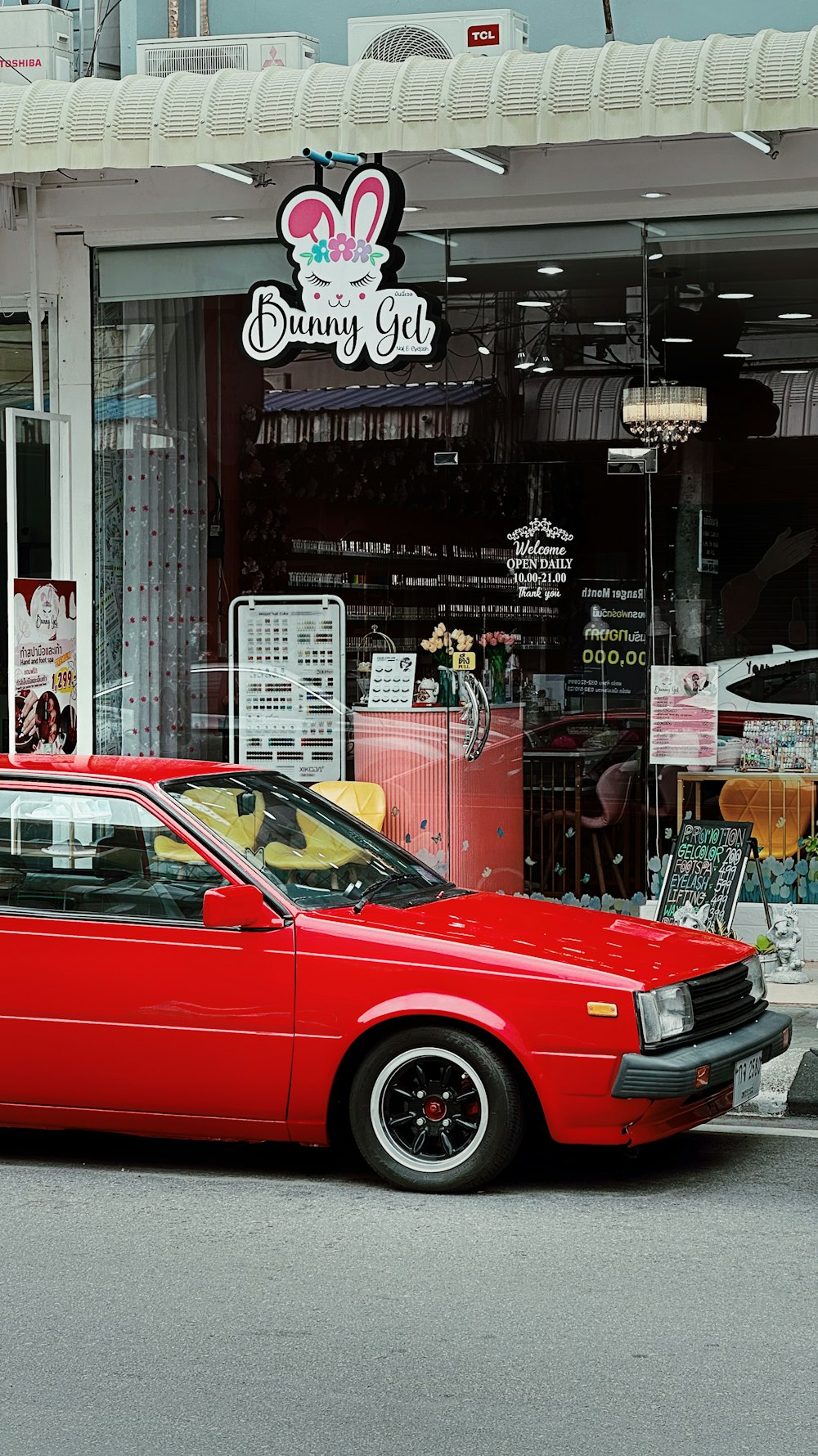 a red car parked in front of a store