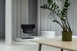 A sleek black swivel chair positioned beside a minimalist wooden desk.