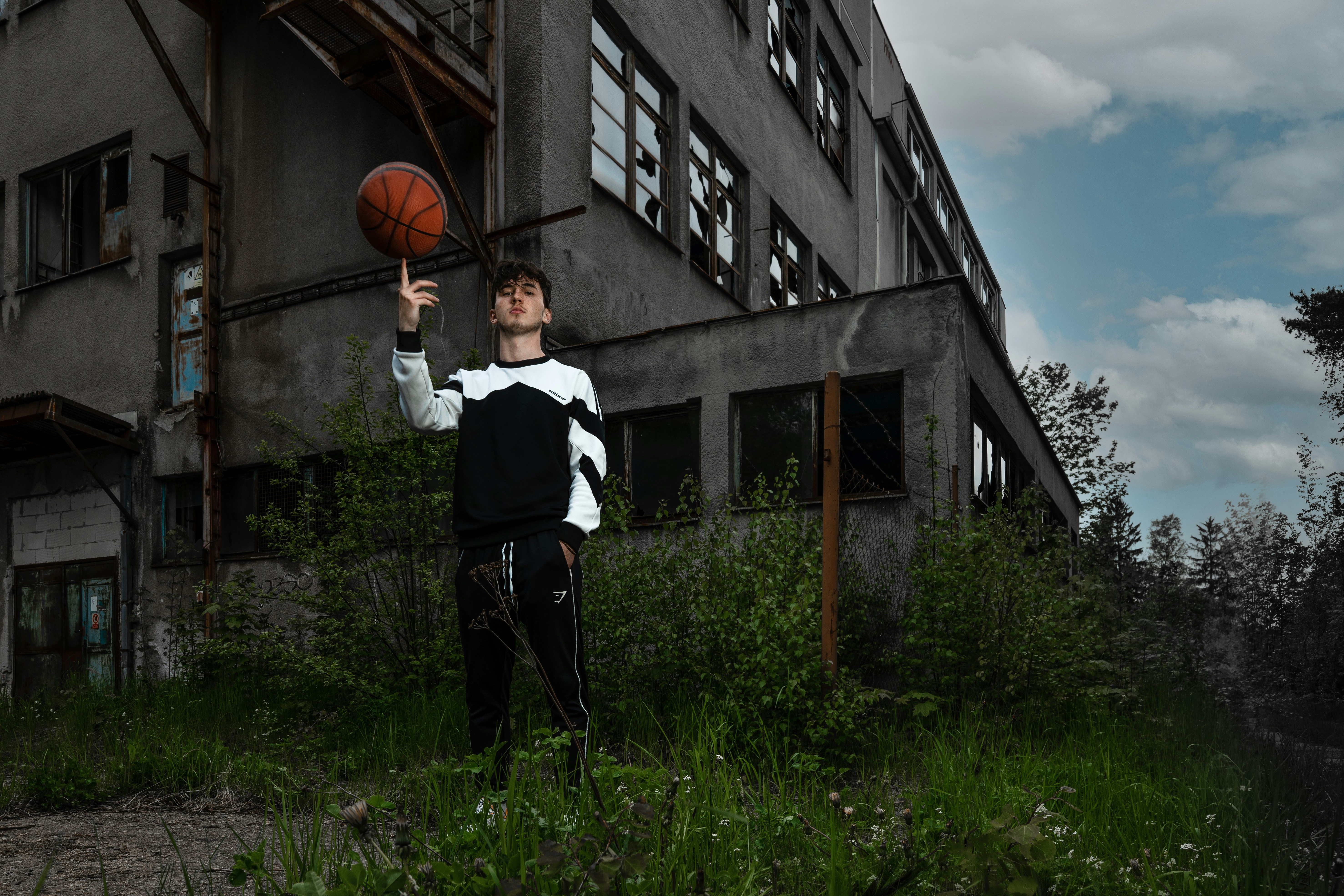 a man holding a basketball in front of a building
