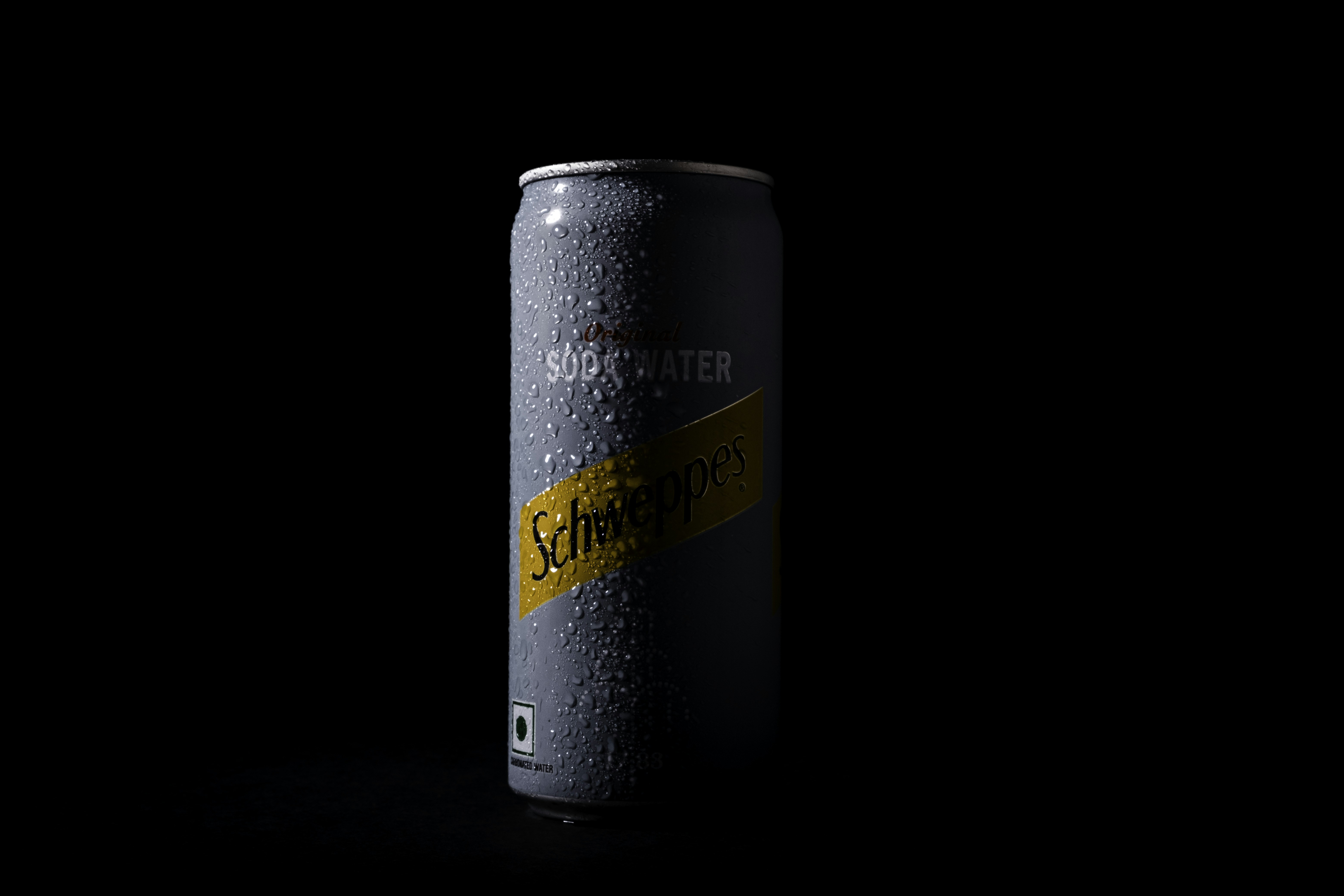 a can of soda on a black background