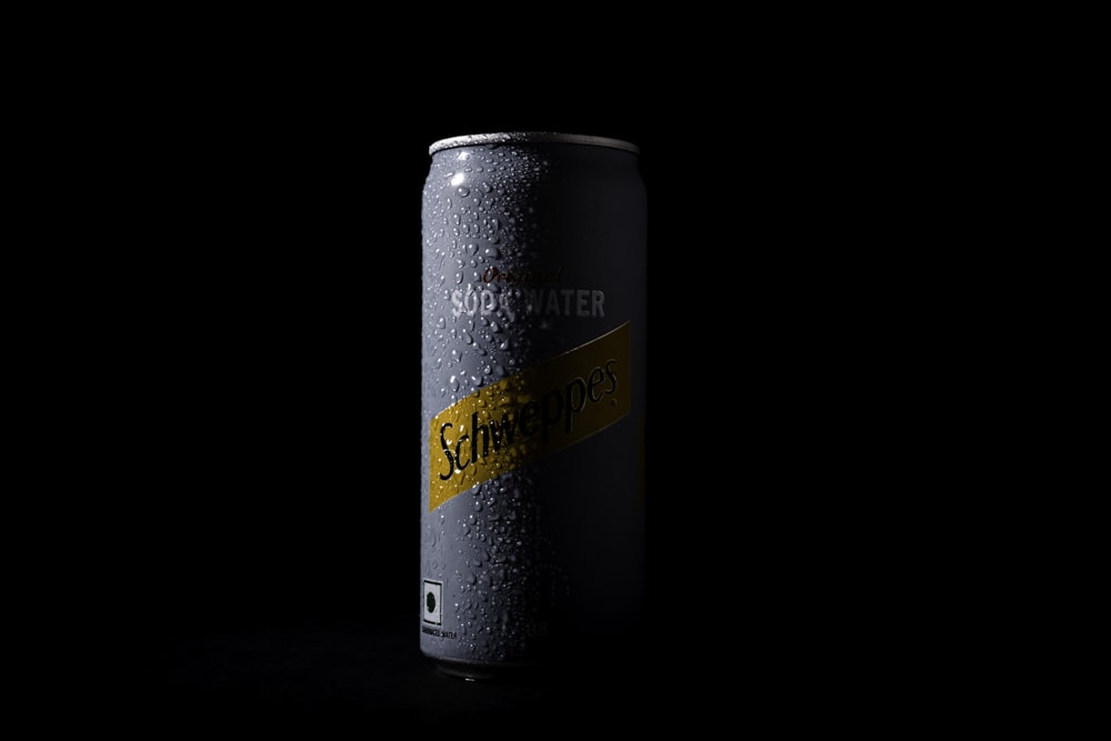 a can of soda on a black background
