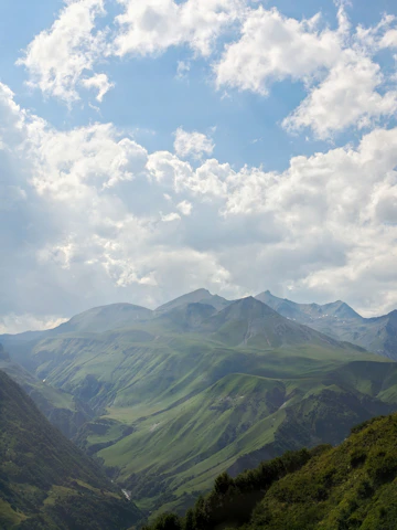 A serene Welsh landscape with rolling green hills under a bright sky, reflecting Cytara’s roots.