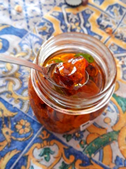 Jar of homemade marmalade with a rustic cloth cover on a wooden table