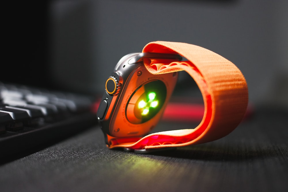 a close up of a watch on a desk near a keyboard