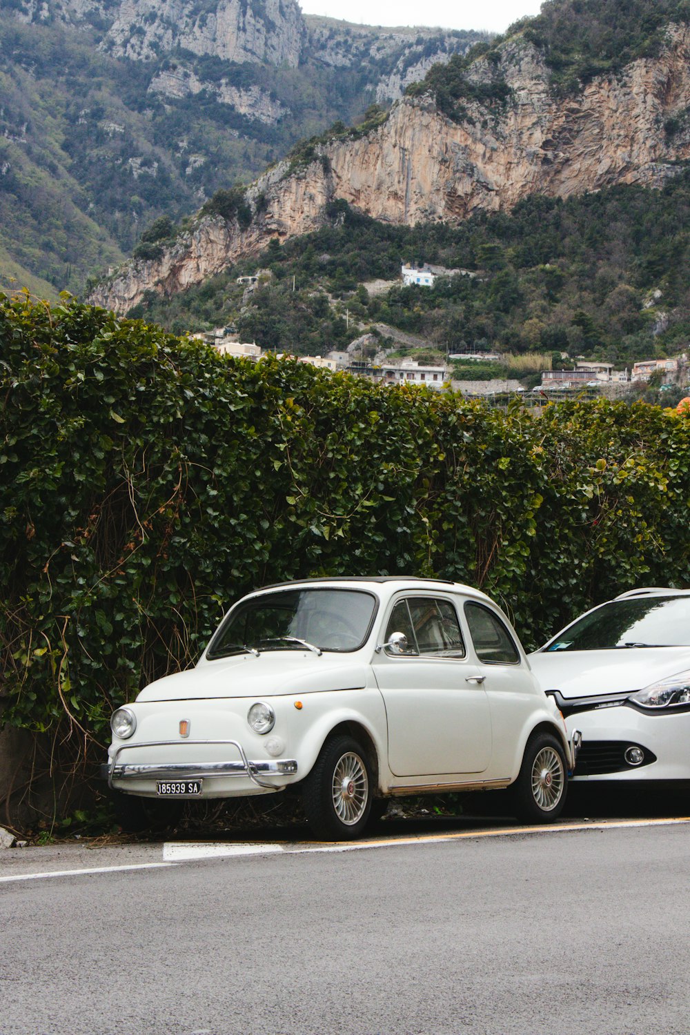 two cars parked next to each other on the side of the road