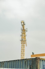 a yellow crane sitting on top of a train track