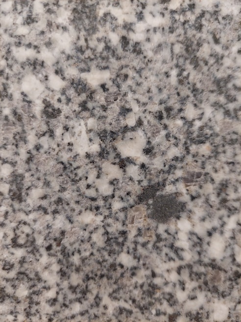 Macro shot of polished granite grains with deep charcoal and subtle bronze hints