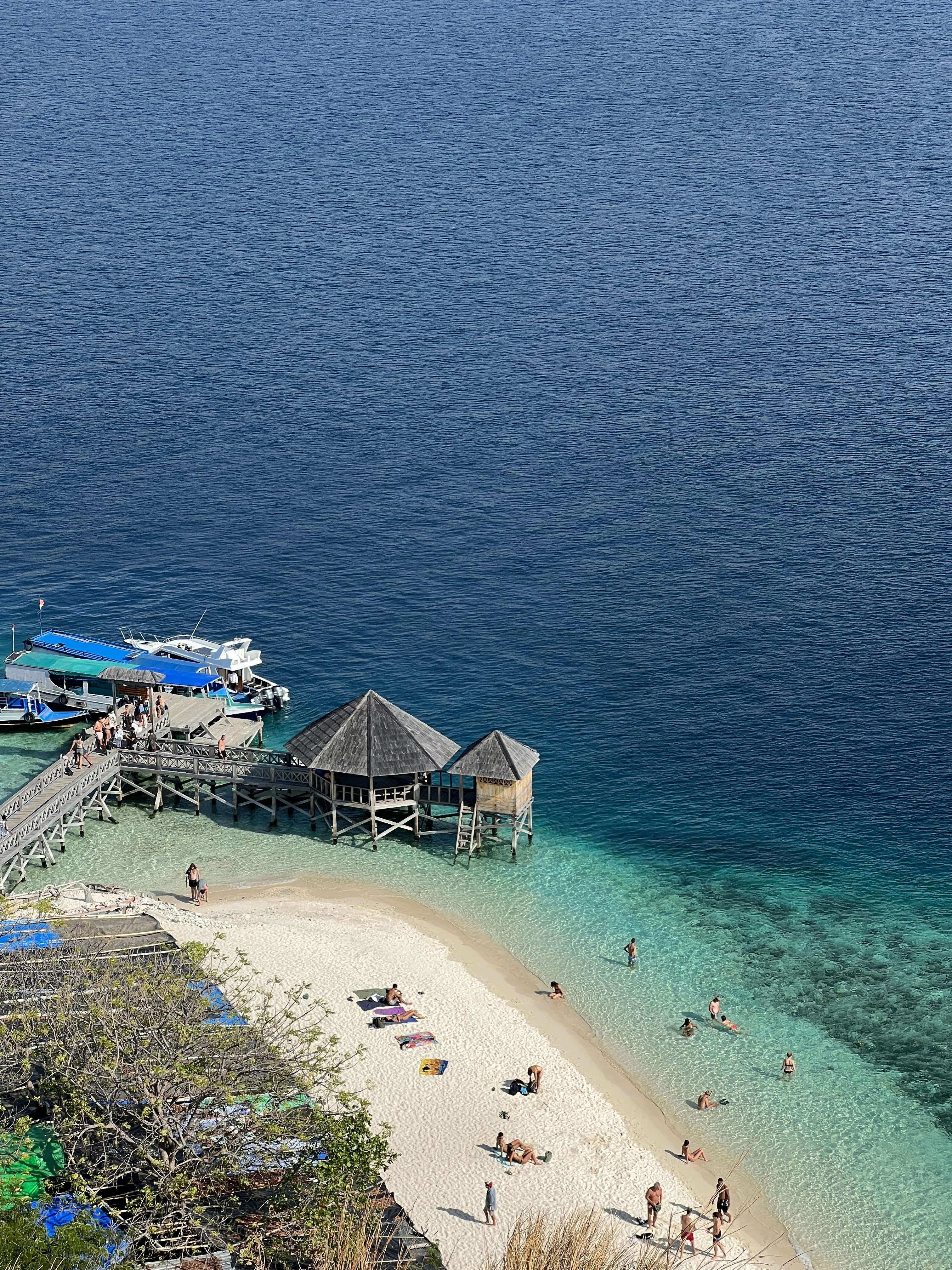 a group of people standing on top of a sandy beach