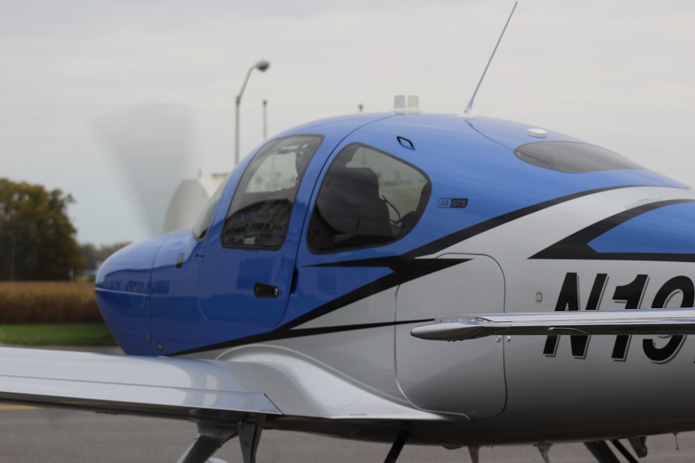 a small blue and silver airplane sitting on top of a runway