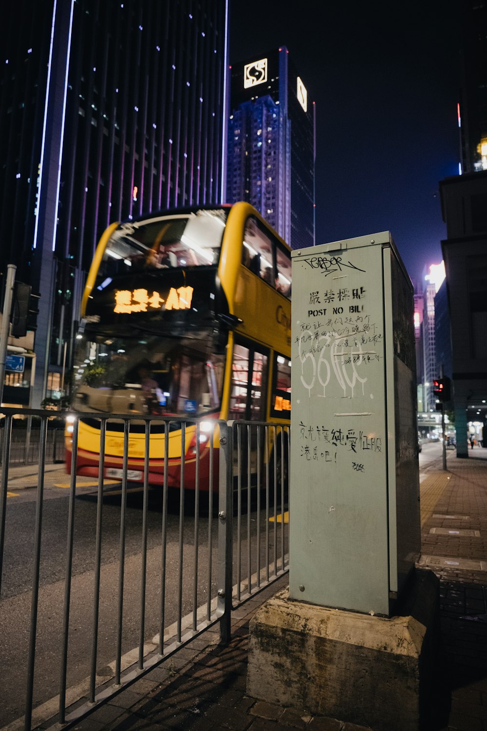 a double decker bus driving past a tall building