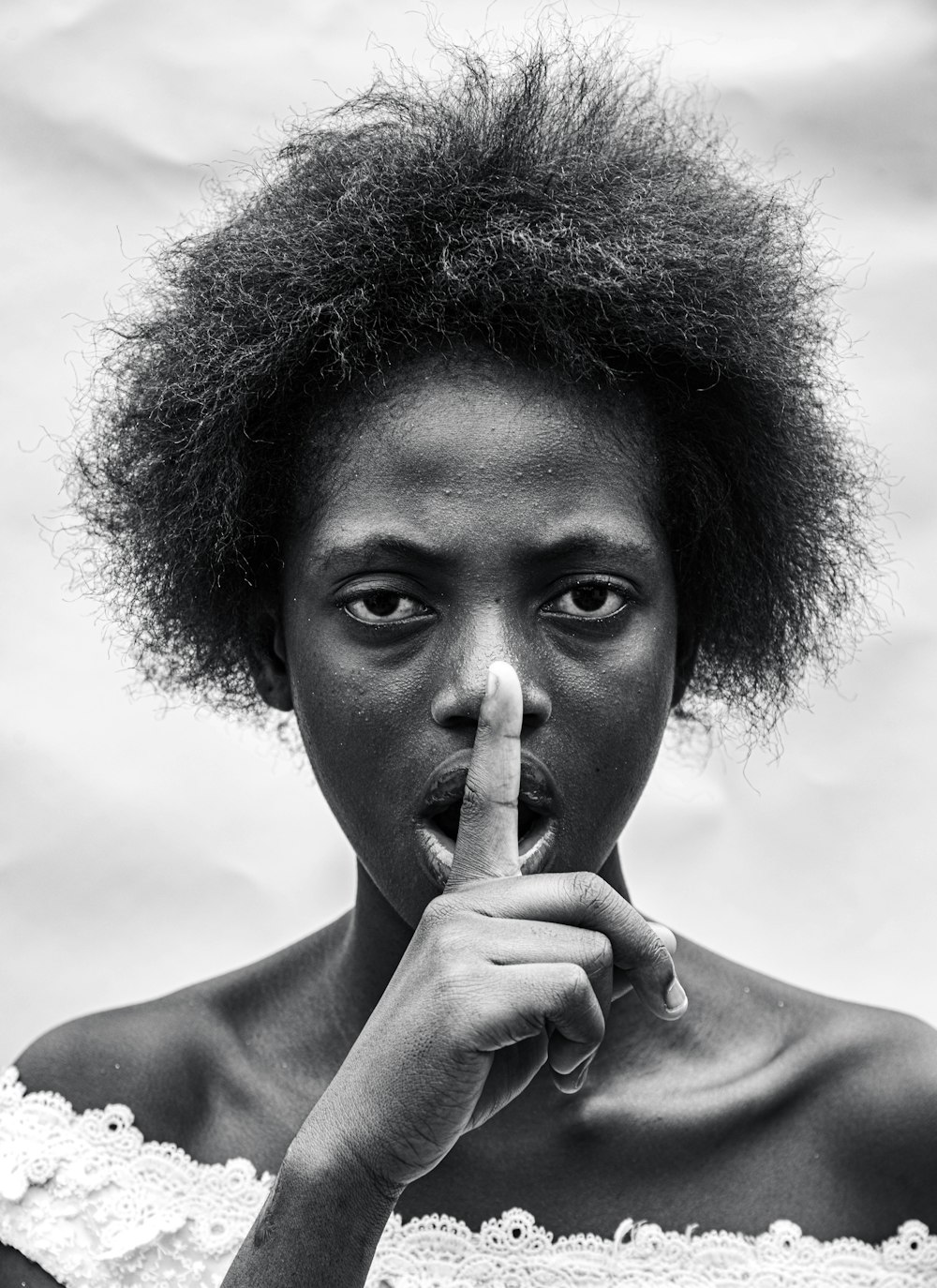 a black and white photo of a woman making a finger sign