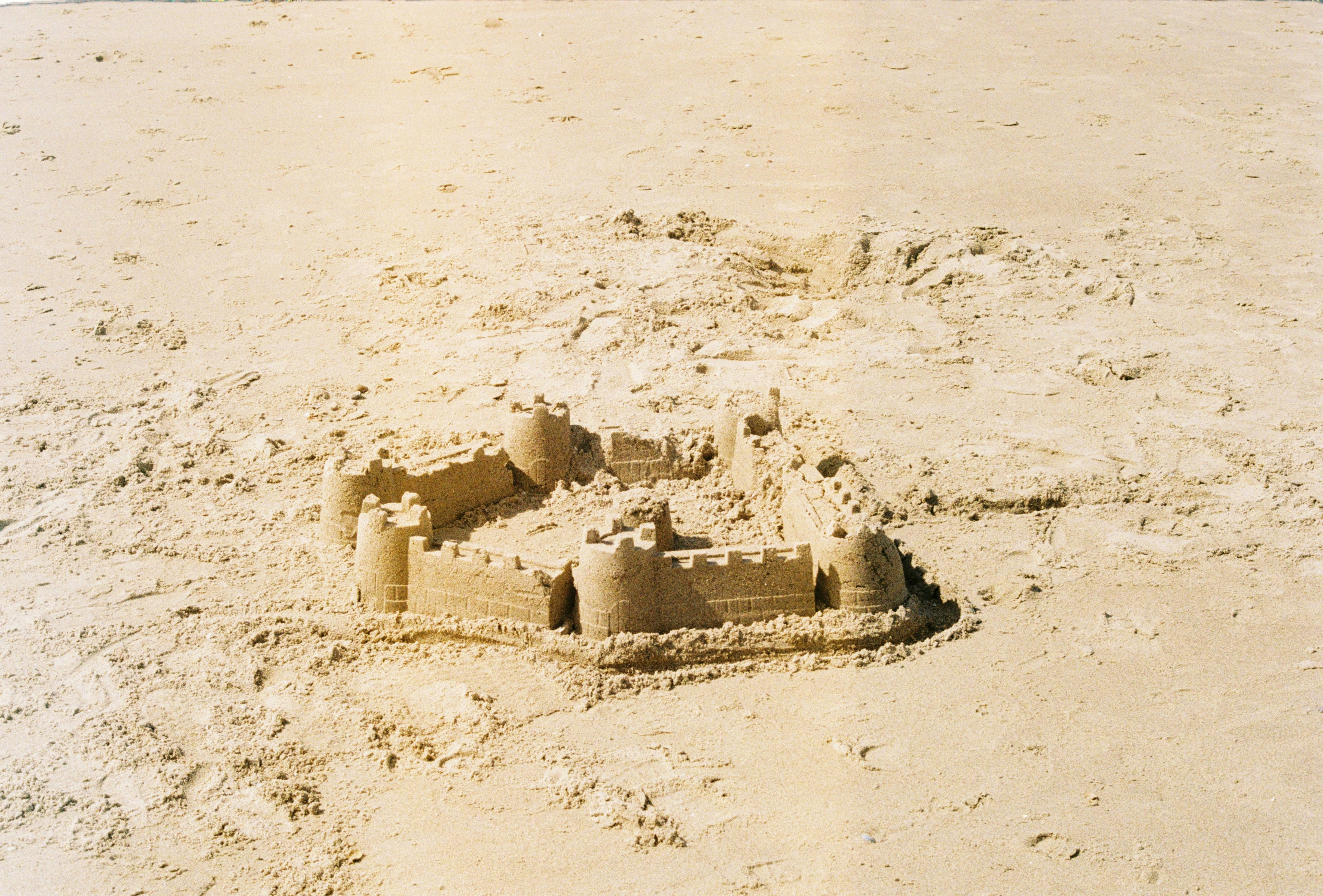 A sand castle made of sand on a beach photo Free Film photography