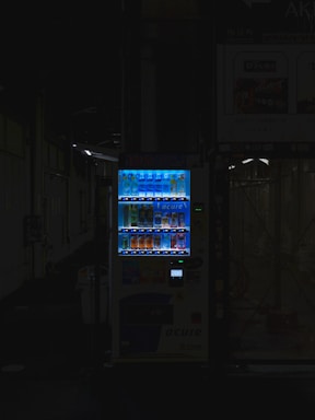 A modern vending machine in a busy office environment.