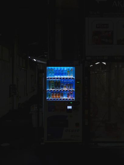 A sleek vending machine glowing softly in a modern apartment lobby with diverse tenants interacting nearby.