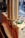 Stacks of ice cream cones are neatly arranged in a transparent vertical holder attached to an ice cream cart with tastefully designed graphics and branding.
