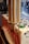 Stacks of ice cream cones are neatly arranged in a transparent vertical holder attached to an ice cream cart with tastefully designed graphics and branding.