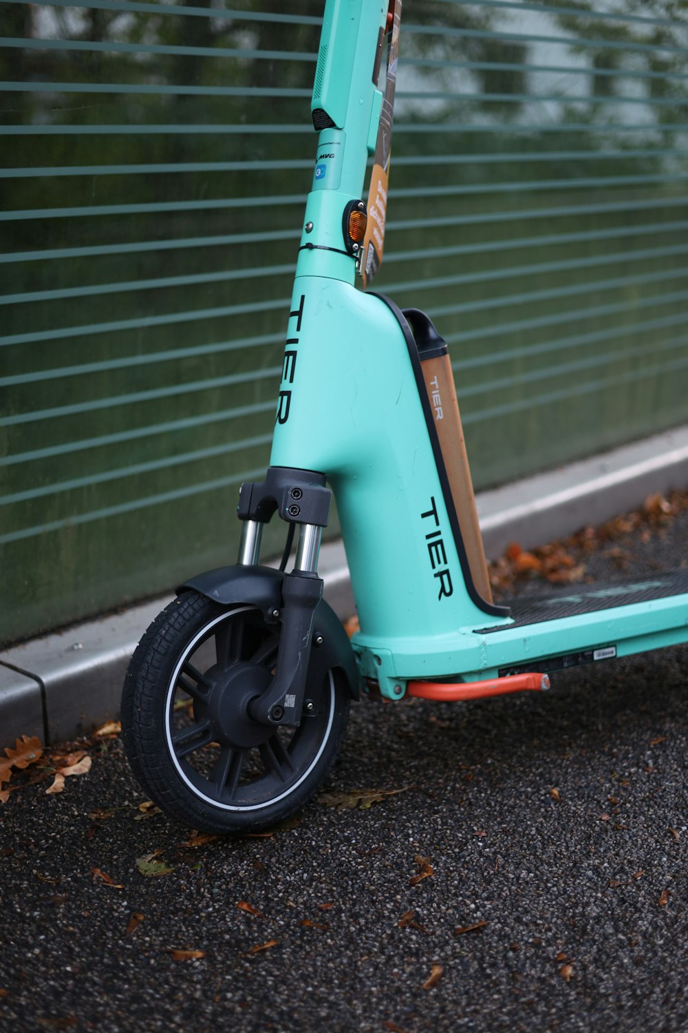 a blue scooter parked next to a fence