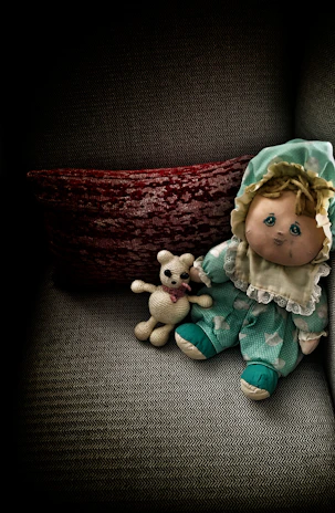A cozy scene of a child hugging a plush doll from Minkštukas, surrounded by colorful toys.