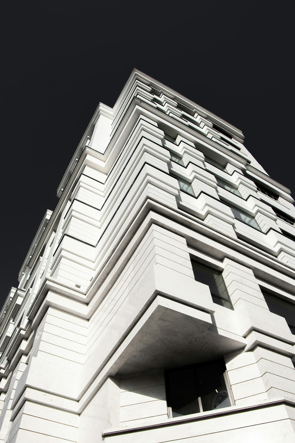 a tall white building with a sky background