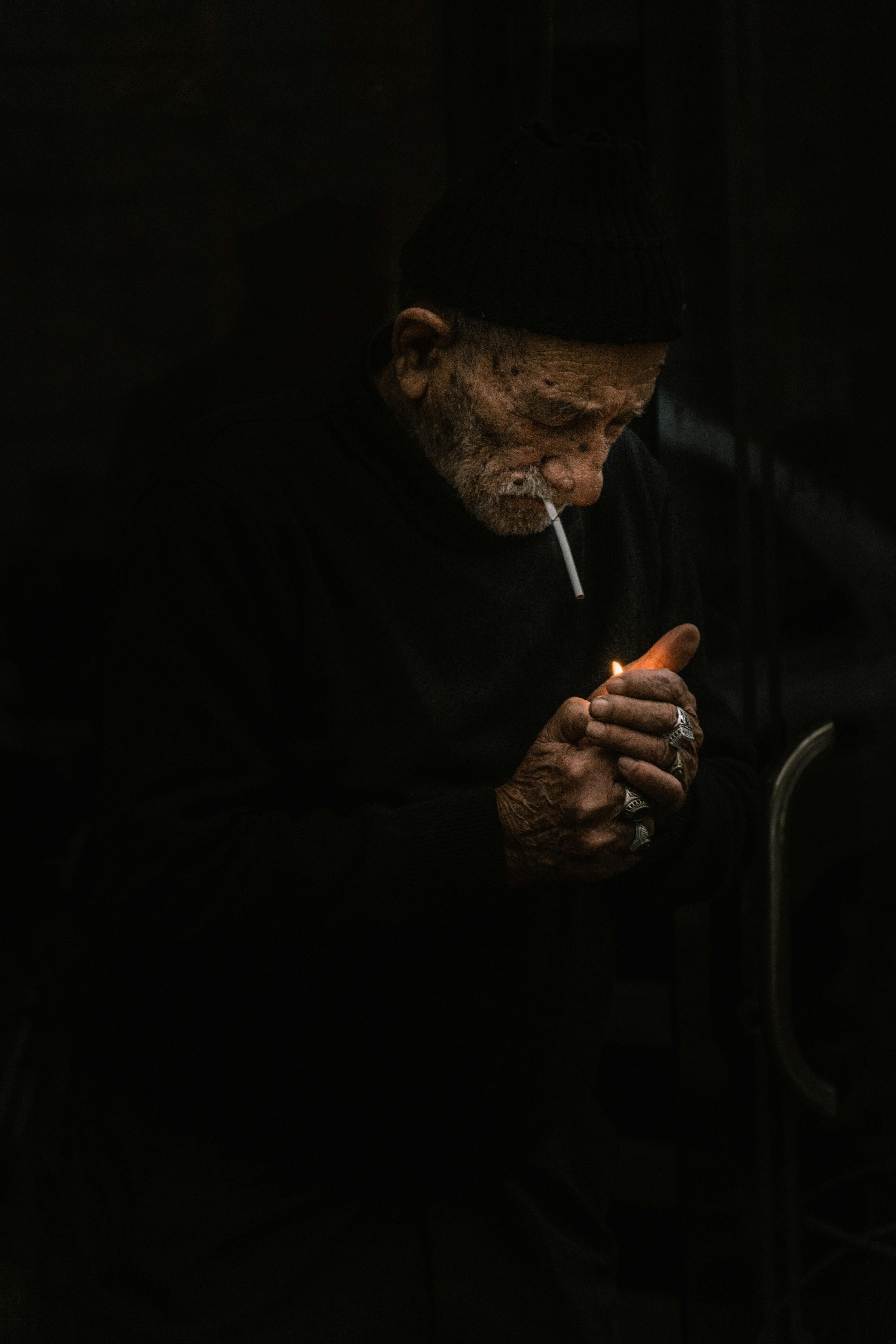 Un hombre fumando un cigarrillo en la oscuridad